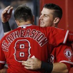Los Angeles Angels' Taylor Featherston (8) and Johnny Giavotella, right, hug after both hit home runs against the Arizona Diamondbacks during the third inning of a baseball game Thursday, June 18, 2015, in Phoenix. (AP Photo/Ross D. Franklin)