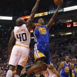 Golden State Warriors forward Harrison Barnes, right, drives on Phoenix Suns forward Anthony Tolliver during the first quarter of an NBA basketball game, Sunday, Nov. 9, 2014, in Phoenix. (AP Photo/Rick Scuteri)