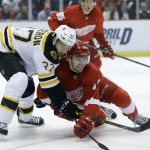 Boston Bruins center Patrice Bergeron (37) and Detroit Red Wings center Riley Sheahan (15) battle for the puck during the first period of Game 3 of a first-round NHL hockey playoff series in Detroit, Tuesday, April 22, 2014. (AP Photo/Carlos Osorio)