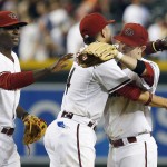 Arizona Diamondbacks' Aaron Hill, right, celebrates his diving stop of a ground ball for the final out in the ninth inning of a baseball game against the Detroit Tigers with teammates Martin Prado, middle, and Didi Gregorius, left, on Tuesday, July 22, 2014, in Phoenix. The Diamondbacks won 5-4. (AP Photo)
