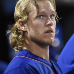 New York Mets pitcher Noah Syndergaard watches from the dugout after leaving the baseball game against the Arizona Diamondbacks on Friday, July 10, 2015, Syndergaard got the win as the Mets defeated the Diamondbacks 4-2. Syndergaard struck out a career-high 13 in eight innings. (AP Photo/Bill Kostroun)
