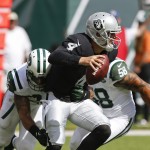 Oakland Raiders quarterback Derek Carr (4) looks to pass as he is sacked by New York Jets' Dawan Landry (26) during the second half of an NFL football game Sunday, Sept. 7, 2014, in East Rutherford, N.J. (AP Photo/Seth Wenig)