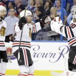 Chicago Blackhawks goalie Corey Crawford (50) is congratulated by center Antoine Vermette (80) and defenseman Kimmo Timonen (44) after the Blackhawks beat the Tampa Bay Lightning 2-1 in Game 5 of the NHL hockey Stanley Cup Final, Saturday, June 13, 2015, in Tampa, Fla. (AP Photo/Chris O'Meara)