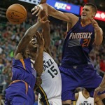 Phoenix Suns' Alex Len, right, Eric Bledsoe, left, and Utah Jazz' Derrick Favors fight for a rebound during the first half of an NBA basketball game in Salt Lake City, Saturday, Nov. 1, 2014. (AP Photo/George Frey)