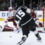 Los Angeles Kings left wing Andy Andreoff shoots and scores pas Arizona Coyotes defenseman Klas Dahlbeck, left, defenseman John Moore, center, and goalie Mike Smith, right, during the second period of an NHL hockey game, Monday, March 16, 2015, in Los Angeles. (AP Photo/Danny Moloshok)