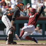 Arizona Diamondbacks' Cody Ross, right, slides to score beside San Francisco Giants catcher Buster Posey in the third inning of a spring training exhibition baseball game Tuesday, March 17, 2015, in Scottsdale, Ariz. Ross scored on a double by Arizona's Brandon Drury. (AP Photo/Ben Margot)