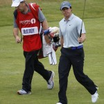 Rory McIlroy of Northern Ireland acknowledges the crowd as he walks with his caddie JP Fitzgerald up to the 18th green during the third day of the British Open Golf championship at the Royal Liverpool golf club, Hoylake, England, Saturday July 19, 2014. (AP Photo/Peter Morrison)