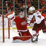 Detroit Red Wings goalie Jimmy Howard (35) deflects a shot by Arizona Coyotes left wing Craig Cunningham (22) during the third period of an NHL hockey game in Detroit on Tuesday, March 24, 2015. Arizona won 5-4 in a shootout. (AP Photo/Paul Sancya)