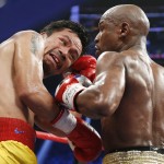 Manny Pacquiao, from the Philippines, left, trades punches with Floyd Mayweather Jr., during their welterweight title fight on Saturday, May 2, 2015 in Las Vegas. (AP Photo/John Locher)