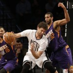 Phoenix Suns' Marcus Morris (15) knocks the ball away from Brooklyn Nets' Brook Lopez (11) as Suns' Brandan Wright (32) also defends during the first half of an NBA basketball game Friday, March 6, 2015, in New York. (AP Photo/Frank Franklin II)
