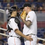 Miami Marlins catcher J.T. Realmuto (20) and Miami Marlins starting pitcher Mat Latos (35) have a mound conference during the fifth inning of a baseball game in Miami against the Arizona Diamondbacks, Thursday, May 21, 2015. The Diamondbacks won 7-6, sweeping the series. (AP Photo/J Pat Carter)