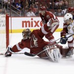 Buffalo Sabres' Patrick Kaleta (36) gets his shot turned away by a diving Arizona Coyotes' Mike Smith, left, as Coyotes' Andrew Campbell (45) and Joe Vitale (14) arrive late to defend during the first period of an NHL hockey game Monday, March 30, 2015, in Glendale, Ariz. (AP Photo/Ross D. Franklin)