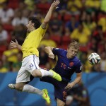 Brazil's Maxwell, left, and Netherlands' Dirk Kuyt leap in the air after attempting to head the ball during the World Cup third-place soccer match between Brazil and the Netherlands at the Estadio Nacional in Brasilia, Brazil, Saturday, July 12, 2014. (AP Photo/Natacha Pisarenko)