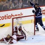 Winnipeg Jets' Andrew Ladd (16) celebrates after Bryan Little (not shown) opened the scoring by putting the the puck past Arizona Coyotes' goaltender Mike Smith, left, during first-period NHL hockey game action in Winnipeg, Manitoba, Sunday, Jan. 18, 2015. (AP Photo/The Canadian Press, Trevor Hagan)
