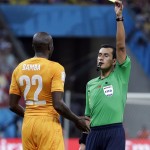  Referee Enrique Osses from Chile gives a yellow card to Ivory Coast's Sol Bamba during the group C World Cup soccer match between Ivory Coast and Japan at the Arena Pernambuco in Recife, Brazil, Saturday, June 14, 2014. (AP Photo/Ricardo Mazalan)