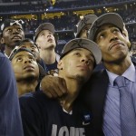 Connecticut head coach Kevin Ollie right, embraces guard Shabazz Napier as the team watches a highlight video of March Madness after their team beat Kentucky, 60-54 at the NCAA Final Four tournament college basketball championship game Monday, April 7, 2014, in Arlington, Texas. (AP Photo/David J. Phillip)