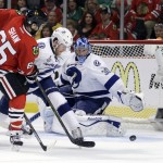 Chicago Blackhawks' Andrew Shaw, left, tries to get off a shot as Tampa Bay Lightning's Matt Carle and goalie Ben Bishop, right, defend during the second period in Game 6 of the NHL hockey Stanley Cup Final series on Monday, June 15, 2015, in Chicago. (AP Photo/Nam Y. Huh)