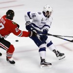 Tampa Bay Lightning's Nikita Kucherov, of Russia, skates past a puck as Chicago Blackhawks' Johnny Oduya, left, of Sweden, defends during the first period in Game 6 of the NHL hockey Stanley Cup Final series on Monday, June 15, 2015, in Chicago. (AP Photo/Charles Rex Arbogast)