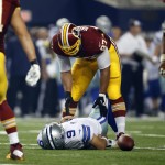 Washington Redskins' Jason Hatcher (97) checks on Dallas Cowboys quarterback Tony Romo (9) who lays on the ground injured after being sacked by the Redskins' Keenan Robinson during the second half of an NFL football game, Monday, Oct. 27, 2014, in Arlington, Texas. (AP Photo/Tim Sharp)