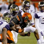 Oklahoma State running back Desmond Roland carries the football as Washington linebacker Cory Littleton (42) makes the tackle during the first half of the Cactus Bowl NCAA college football game, Friday, Jan. 2, 2015, in Tempe, Ariz. (AP Photo/Matt York)

