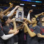 Wisconsin players hold the trophy after beating Arizona 85-78 in a college basketball regional final in the NCAA Tournament to advance to the Final Four, Saturday, March 28, 2015, in Los Angeles. (AP Photo/Mark J. Terrill)