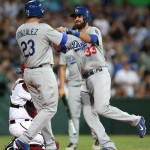 The Dodgers' Scott Van Slyke, right, is congratulated by teammate Adrian Gonzalez after Van Slyke hit a two-run home run in the Major League Baseball opening game between the Los Angeles Dodgers and Arizona Diamondbacks at the Sydney Cricket ground in Sydney, Saturday, March 22, 2014. (AP Photo/Rick Rycroft)
