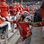 Los Angeles Angels' Taylor Featherston, middle, smiles as he starts to celebrate his home run against the Arizona Diamondbacks with teammates, including Mike Trout, right, during the third inning of a baseball game Thursday, June 18, 2015, in Phoenix. (AP Photo/Ross D. Franklin)