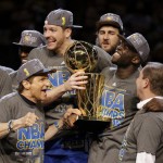 Golden State Warriors forward Draymond Green, with trophy, celebrates with Warriors owners Peter Guber, left, and Joe Lacob after the Warriors won the NBA Finals against the Cleveland Cavaliers in Cleveland, Wednesday, June 17, 2015. The Warriors defeated the Cavaliers 105-97 to win the best-of-seven game series 4-2. (AP Photo/Paul Sancya)(AP Photo/Tony Dejak)
