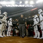 The umpire crew, lead by Doug Eddings, walks onto the field as they are flanked by people dressed as stormtroopers from the "Star Wars" films on Star Wars Day at Chase Field prior to a baseball game between the Arizona Diamondbacks and the Chicago Cubs on Sunday, July 20, 2014, in Phoenix. (AP Photo/Ross D. Franklin)