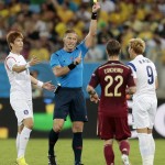 Russia's Andrei Yeshchenko (22) watches as referee Nestor Pitana from Argentina books South Korea's Son Heung-min (9) and Ki Sung-yueng tries to intercede during the group H World Cup soccer match between Russia and South Korea at the Arena Pantanal in Cuiaba, Brazil, Tuesday, June 17, 2014. (AP Photo/Ivan Sekretarev)