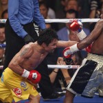 Manny Pacquiao, from the Philippines, left, lands a body punch to Floyd Mayweather Jr., during their welterweight title fight on Saturday, May 2, 2015 in Las Vegas. (AP Photo/Eric Jamison)