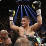 Marcos Maidana, from Argentina, celebrates at the end of his WBC-WBA welterweight title boxing fight against Floyd Mayweather Jr., lower left, Saturday, May 3, 2014, in Las Vegas. Mayweather won the bout by majority decision. (AP Photo/Eric Jamison)