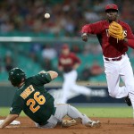 Arizona Diamondbacks' shortstop Didi Gregorius, right, avoids the sliding Australia's Justin Huber to complete a double play during their exhibition baseball game against Team Australia at the Sydney Cricket Ground in Sydney, Friday, March 21, 2014. Major League Baseball will open their season Saturday in Sydney with the Los Angeles Dodgers taking on the Diamondbacks. (AP Photo/Rick Rycroft)