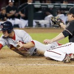 St. Louis Cardinals' Randal Grichuk, left, scores on a wild pitch as Arizona Diamondbacks' Wade Miley, right, applies a late tag during the third inning of a baseball game Saturday, Sept. 27, 2014, in Phoenix. (AP Photo/Ross D. Franklin)