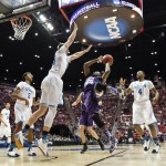 Stephen F. Austin guard Desmond Haymon, center, attempts a fall away shot as UCLA forward Travis Wear, center left, tries for the block during the first half of a third-round game in the NCAA college basketball tournament, Sunday, March 23, 2014, in San Diego. (AP Photo/Gregory Bull)