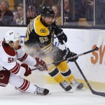 Phoenix Coyotes center Antoine Vermette (50) tries to take the puck from Boston Bruins defenseman Johnny Boychuk during the first period of an NHL hockey game in Boston Thursday, March 13, 2014. (AP Photo/Winslow Townson)
