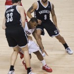 Toronto Raptors guard Kyle Lowry, center, works between Brooklyn Nets' Mirza Teletovic (33) and Deron Williams (8) during the first half of Game 2 in an NBA basketball first-round playoff series, Tuesday, April 22, 2014, in Toronto. (AP Photo/The Canadian Press, Nathan Denette)