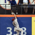 Arizona Diamondbacks left fielder David Peralta attempts to catch a home run by New York Mets' Michael Cuddyer, but a fan catches the ball during the first inning of a baseball game Friday, July 10, 2015, at Citi Field in New York. (AP Photo/Bill Kostroun)
