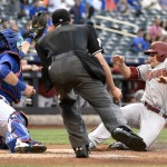 New York Mets catcher Kevin Plawecki takes the throw as Arizona Diamondbacks' A.J. Pollock, right, scores on a sacrifice fly by Paul Goldschmidt during the first inning of a baseball game Friday, July 10, 2015, at Citi Field in New York. Home plate umpire John Tumpane prepares to make the call. (AP Photo/Bill Kostroun)
