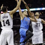 Dallas Mavericks' Chandler Parsons (25) drives between San Antonio Spurs' Danny Green (14) and Tim Duncan (21) to score during the first half of an NBA basketball game, Tuesday, Oct. 28, 2014, in San Antonio. (AP Photo/Eric Gay)