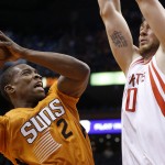 Phoenix Suns' Eric Bledsoe (2) finds in his way to the basket blocked by Houston Rockets' Donatas Motiejunas, of Lithuania, during the second half of an NBA basketball game Friday, Jan. 23, 2015, in Phoenix. The Rockets defeated the Suns 113-111. (AP Photo/Ross D. Franklin)