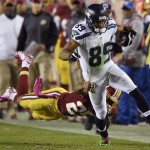 Washington Redskins strong safety Bashaud Breeland (26) hangs on to Seattle Seahawks wide receiver Doug Baldwin (89) during the first half of an NFL football game in Landover, Md., Monday, Oct. 6, 2014. (AP Photo/Nick Wass)