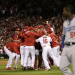 St. Louis Cardinals players celebrate after their 3-2 win over Los Angeles Dodgers in Game 4 of baseball's NL Division Series Tuesday, Oct. 7, 2014, in St. Louis. Los Angeles Dodgers right fielder Yasiel Puig, right, looks on. (AP Photo/Charles Rex Arbogast)