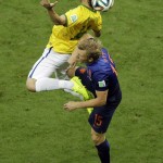 Netherlands' Dirk Kuyt, down, and Brazil's Maxwell go for a header during the World Cup third-place soccer match between Brazil and the Netherlands at the Estadio Nacional in Brasilia, Brazil, Saturday, July 12, 2014. (AP Photo/Themba Hadebe)