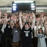 Connecticut students in Storrs, Conn., Monday April 7, 2014, raise their arms during a UConn free throw while they watch the broadcast of the UConn and Kentucky men's basketball game for the NCAA title. (AP Photo/Jessica Hill)