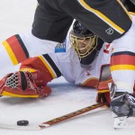 Calgary Flames goalie Jonas Hiller, of Switzerland, dives to cover up the puck during the second period against the Vancouver Canucks in Game 5 of an NHL hockey first-round playoff series, Thursday, April 23, 2015, in Vancouver, British Columbia. (Darryl Dyck/The Canadian Press via AP)