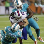 Miami Dolphins strong safety Jimmy Wilson (27) and outside linebacker Jelani Jenkins (53) take down Buffalo Bills wide receiver Chris Hogan (15) during the first half of an NFL football game, Thursday, Nov. 13, 2014, in Miami Gardens, Fla. (AP Photo/Alan Diaz)