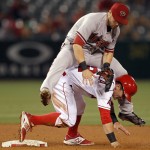 Arizona Diamondbacks second baseman Chris Owings lands on Los Angeles Angels' Johnny Giavotella after making the relay to first to get Carlos Perez for a double play during the eighth inning of a baseball game in Anaheim, Calif., Monday, June 15, 2015. (AP Photo/Alex Gallardo)
