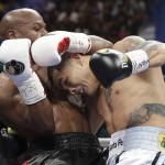 Floyd Mayweather Jr., left, trades blows with Marcos Maidana, from Argentina, in their WBC-WBA welterweight title boxing fight Saturday, May 3, 2014, in Las Vegas. (AP Photo/Isaac Brekken)