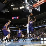 Phoenix Suns forward Marcus Morris, right, pulls in a rebound in front of Denver Nuggets forward Danilo Gallinari, center, of Italy, as Suns forward Brandan Wright, left, looks on in the fourth quarter of an NBA basketball game Wednesday, Feb. 25, 2015, in Denver. The Suns won 110-96. (AP Photo/David Zalubowski)